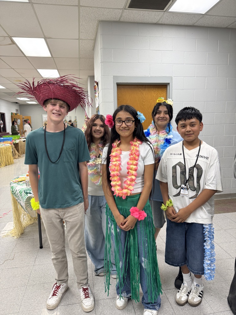 A group of students posing for a picture at the 8th grade luau.