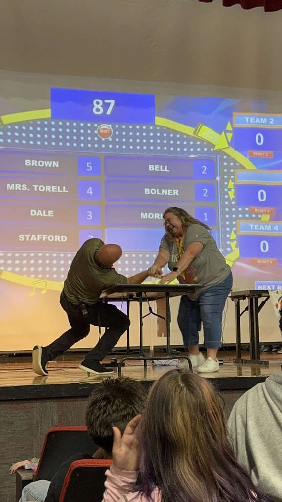 Mr. Moreland and Ms. Cunningham arm wrestling. 