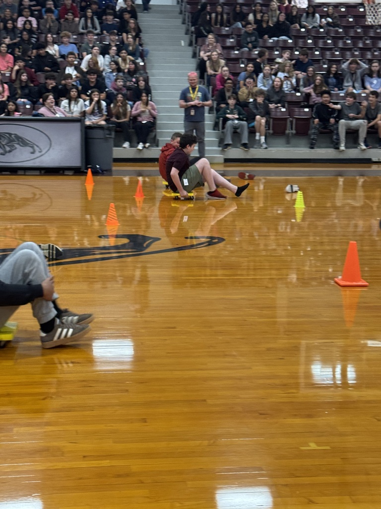 Students riding scooters for the scooter relay race.