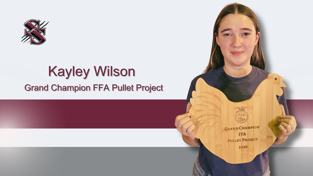 A young girl stands with a wooden chicken plaque, holding it proudly. Behind her, text reads "Kayley Wilson Grand Champion FFA Pullet Project."
