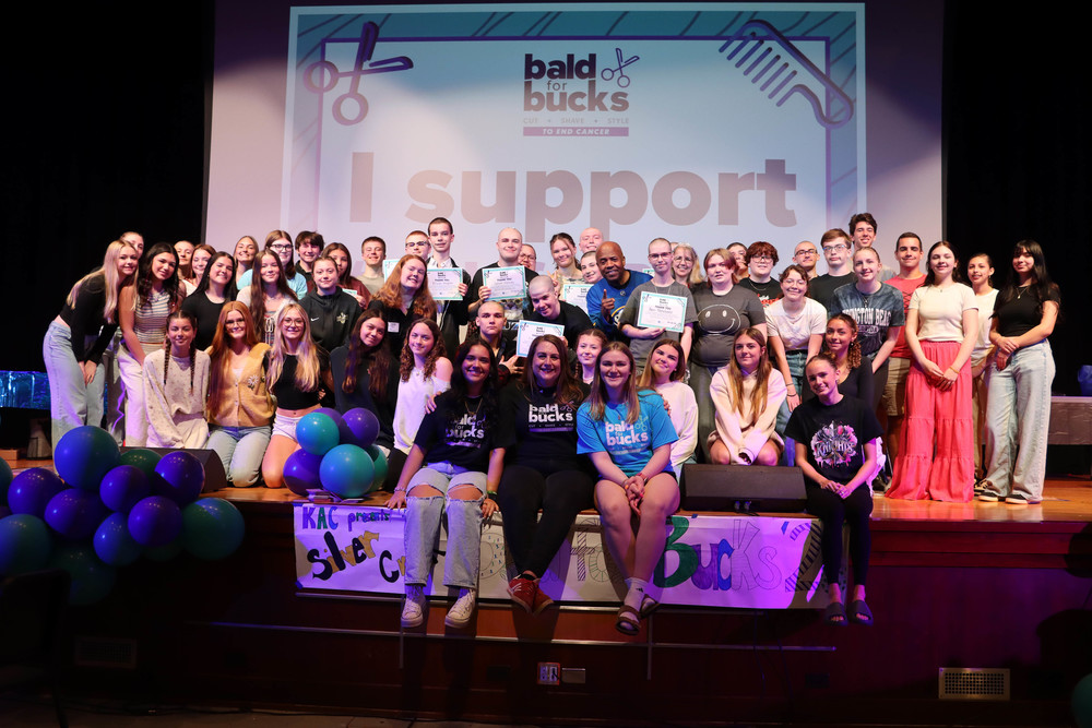 Bald for Bucks participants and volunteers on stage