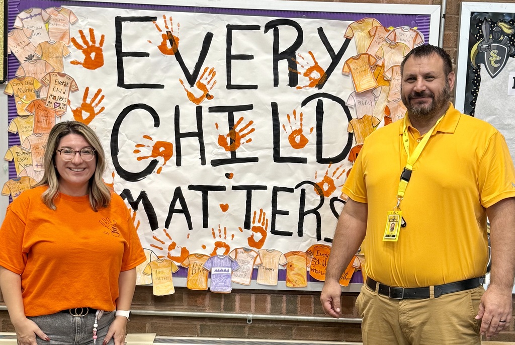 Principals in front of orange banner