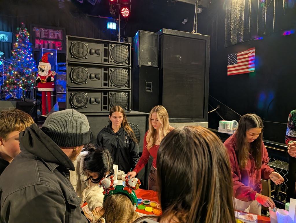 Student volunteers working at painting craft table