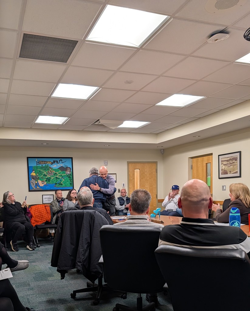 Mr. Graf hugs Mr. Janish at the Board meeting