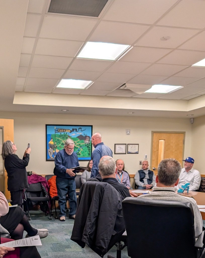 Mr. Helmer hands Mr. Janisch an award