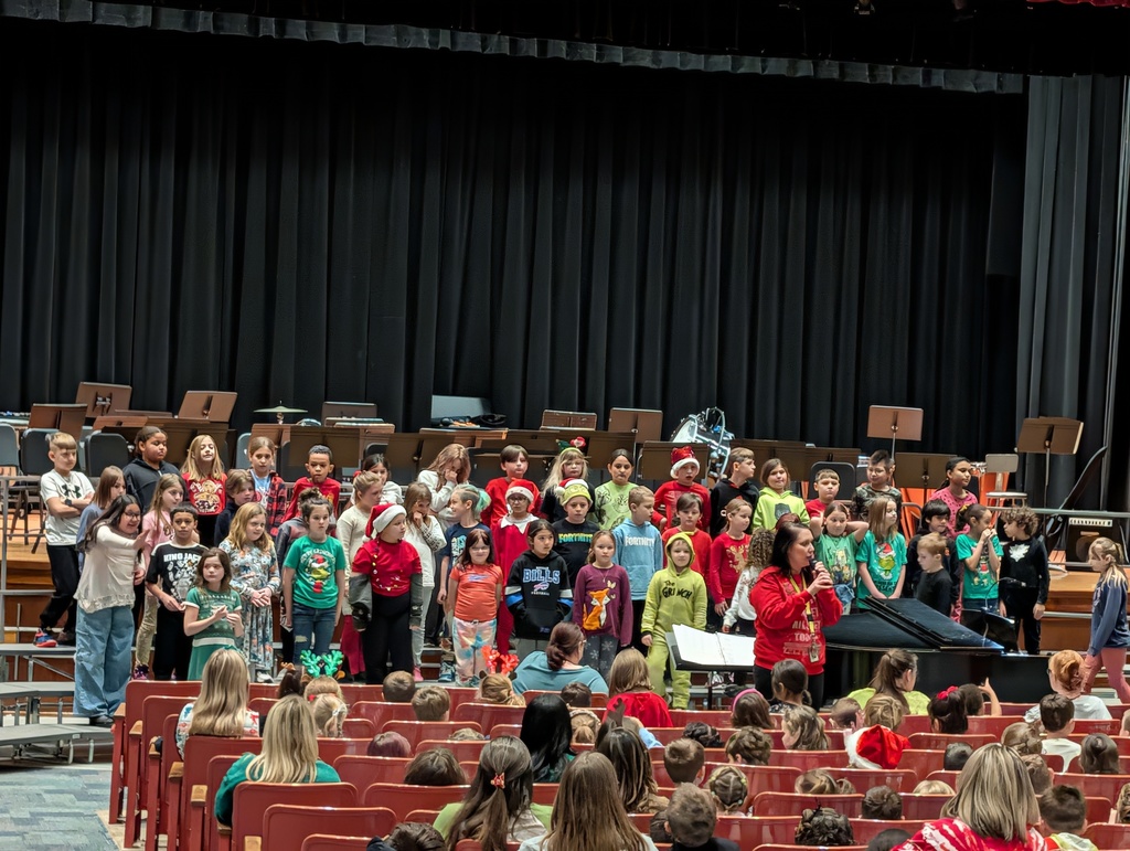 Mrs. Gould speaking with chorus behind her