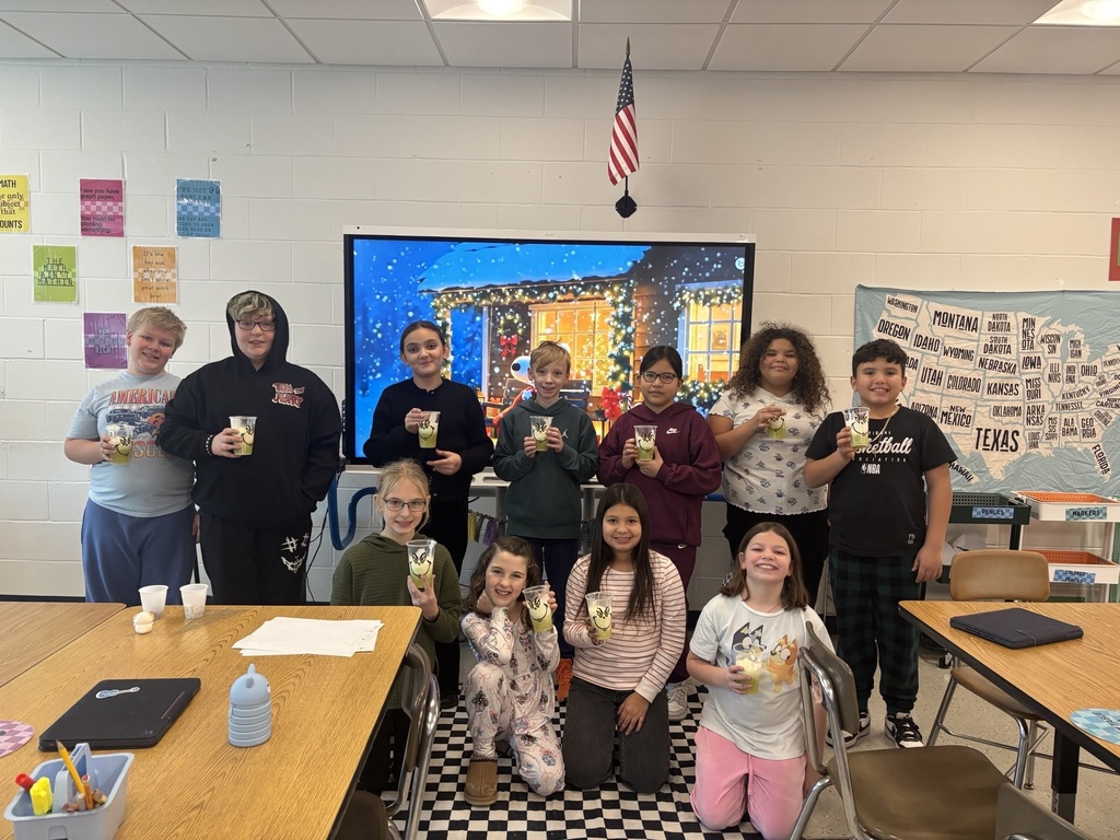 4th grade students holding grinch drinks