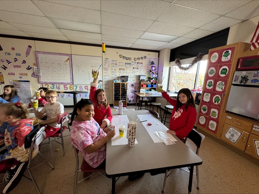 4th grade students holding grinch drinks