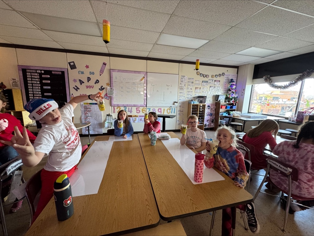 4th grade students holding grinch drinks