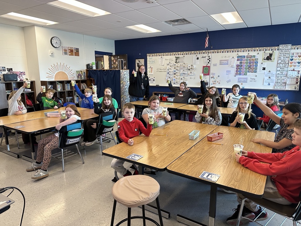4th grade students holding grinch drinks