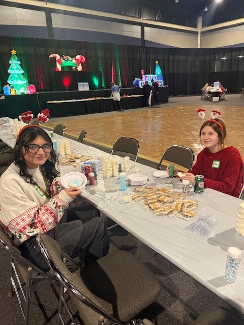 Two students assist with cookie decorating. 