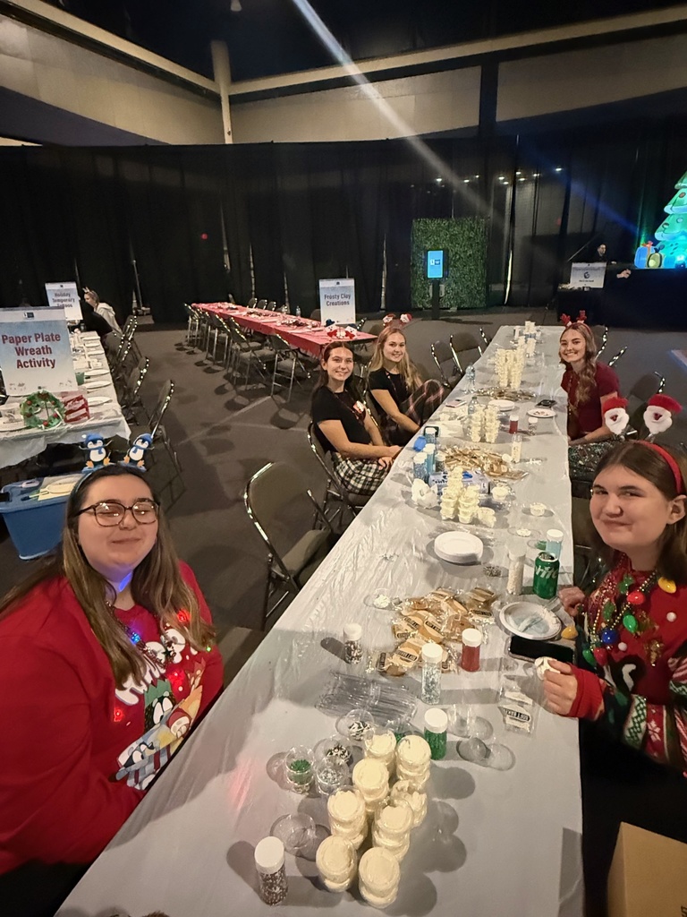 Five female students assist with cookie decorating. 