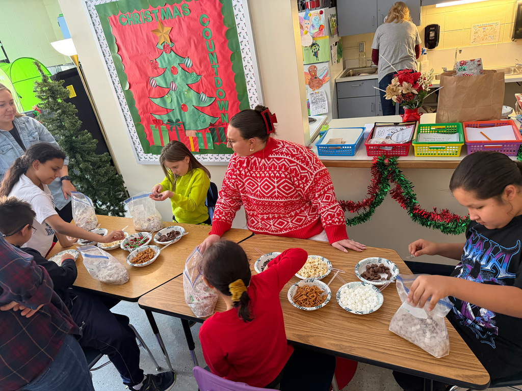 Miss O'Connor supervising children making snack mix