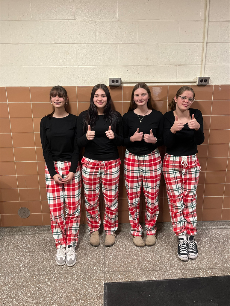 Four female students wear black shirts and red flannel pajama pants.