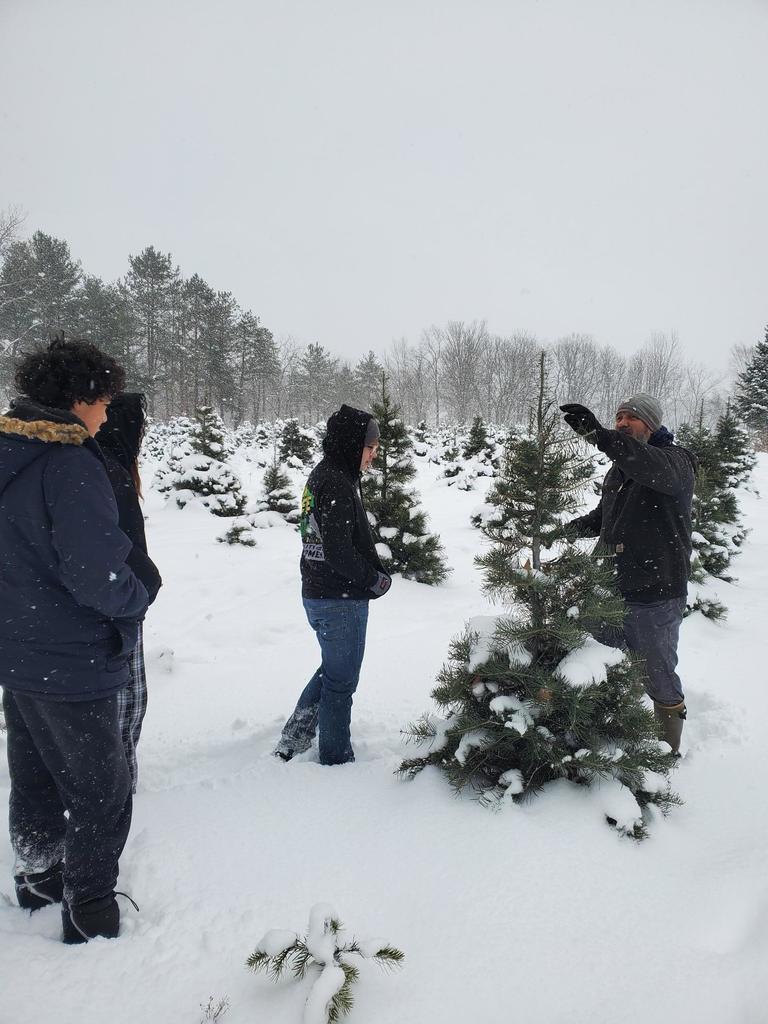 A man points to a tree as students listen.