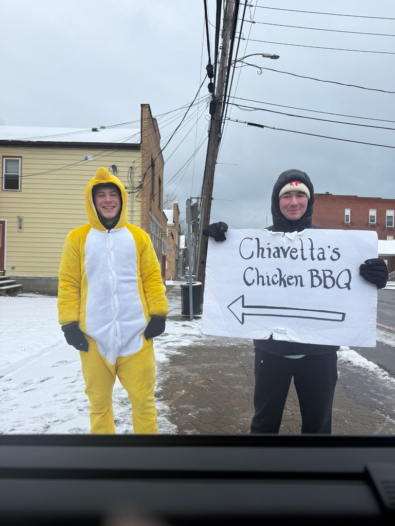 Silver Creek students bundled up outside holding a dinner advertisement sign