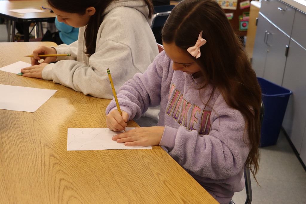 two students draw designs.