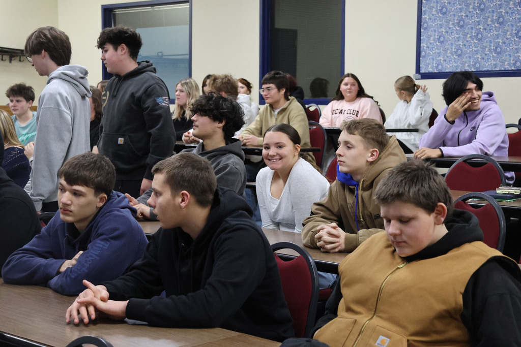 One student smiles as the group listens to the welcoming message. 