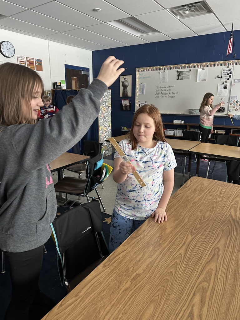 girl catching ruler as another girl drops it