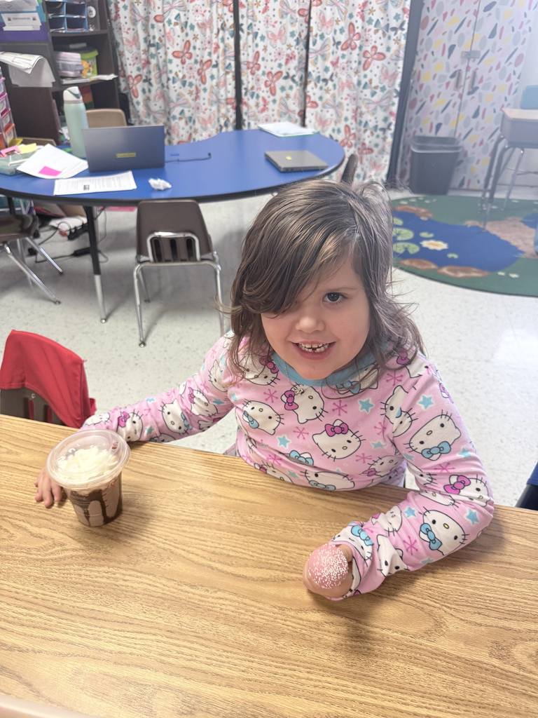 student smiling with special drink and cake pop