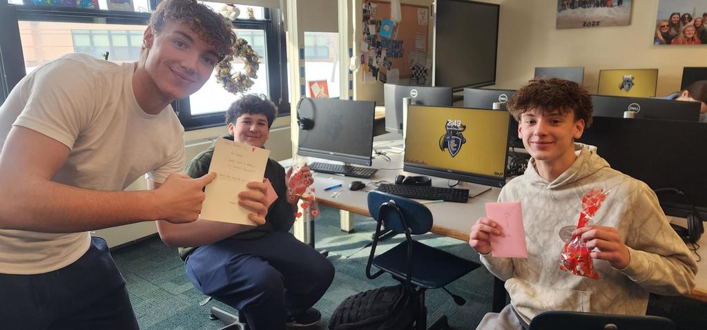 3 male students smiling with cards