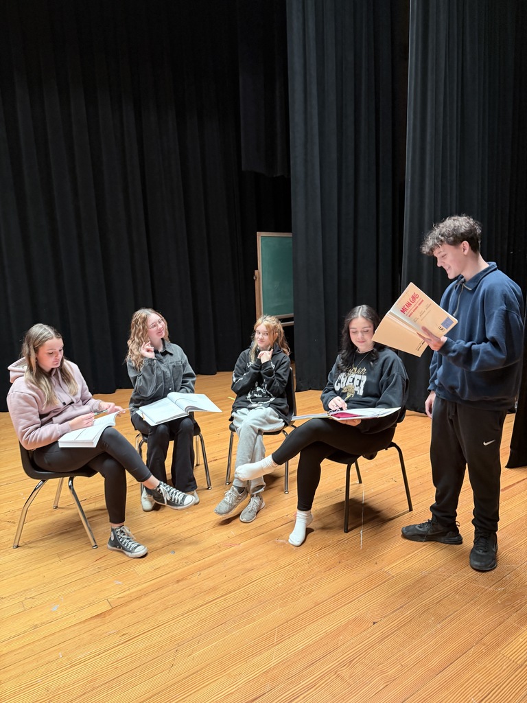a group of students learn their lines. 