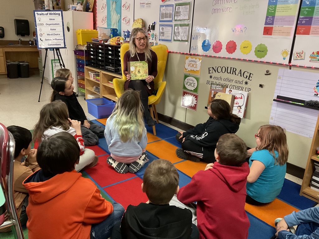 students look on as Miss Neubauer reads a book