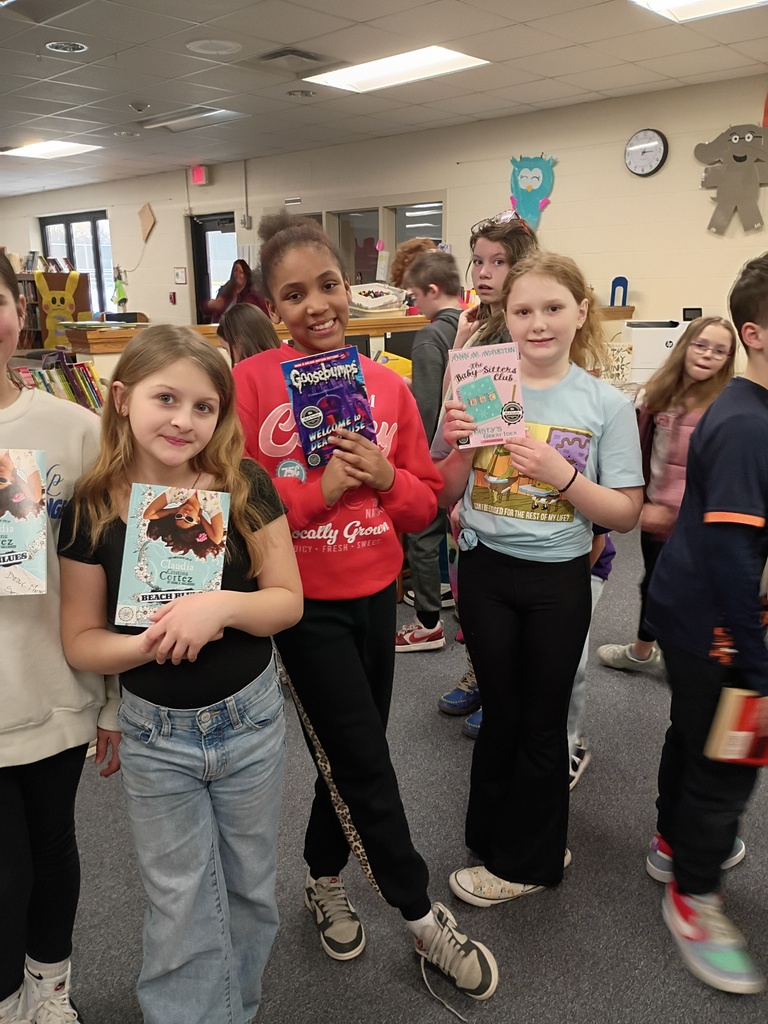 students smiling and holding their book choices