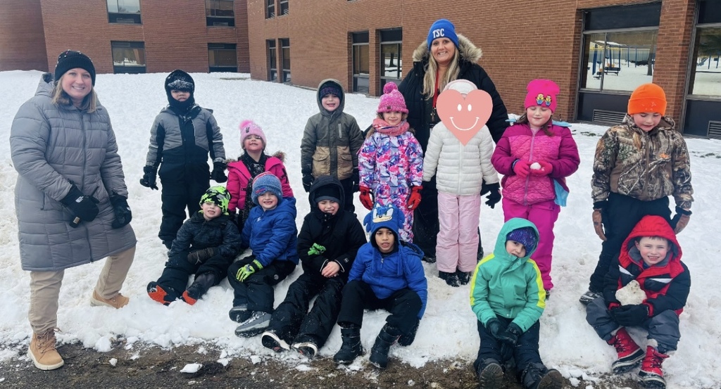 the class poses in the snow. 