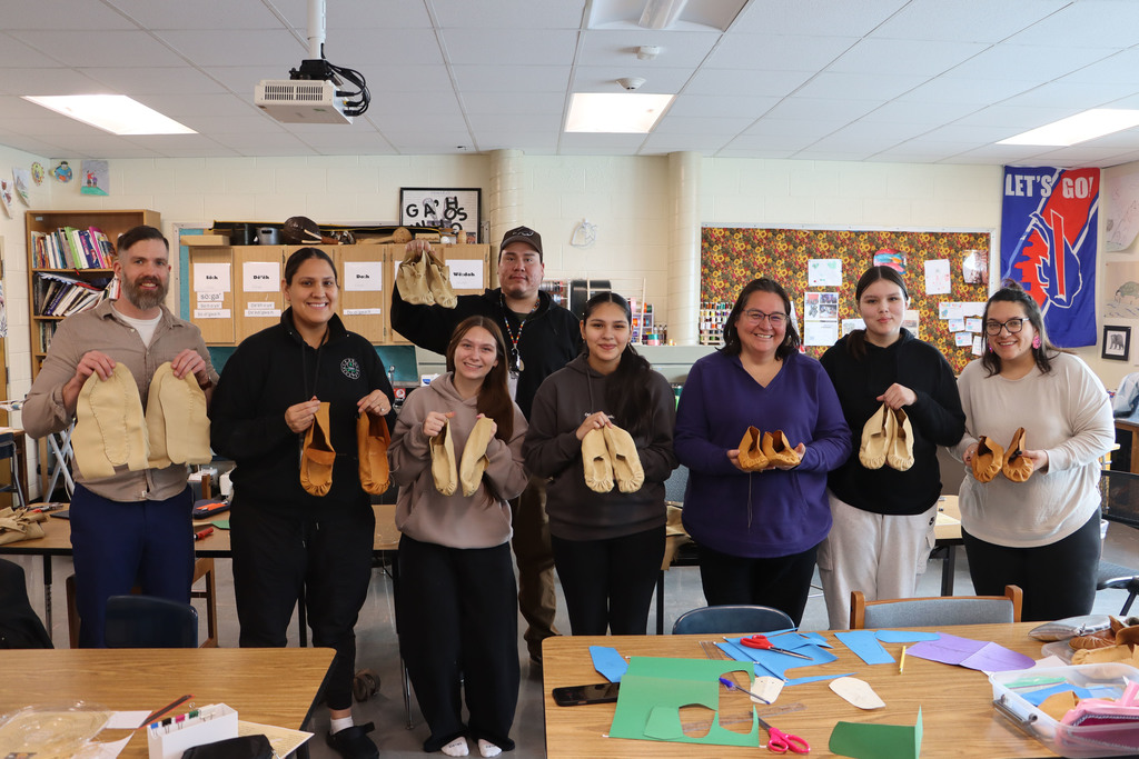 Group holds up their moccasins.
