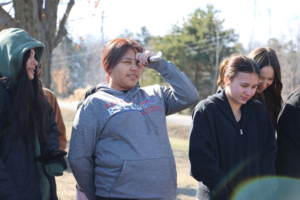 a student looks through a device to measure the sweetness of syrup. 