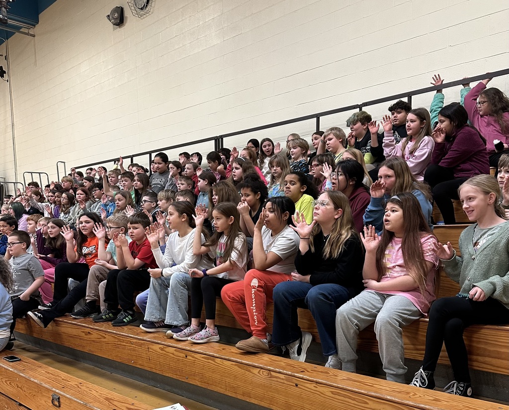 Students applauding in the gym bleachers