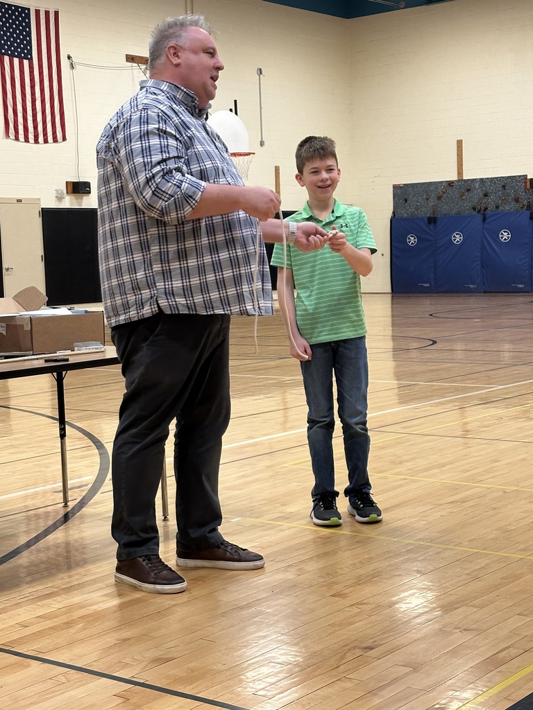 Boy smiling with magician in gym