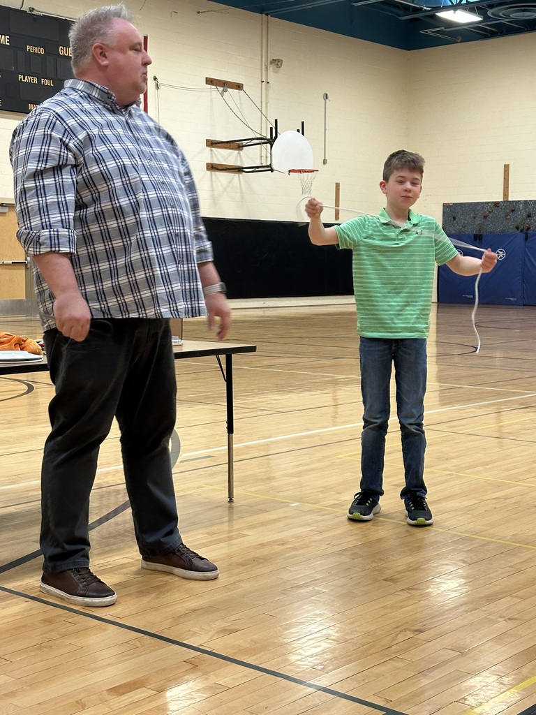 Boy holding string while working with magician in gym