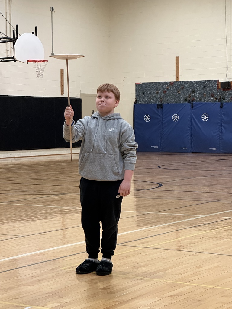 Boy balancing plate on stick