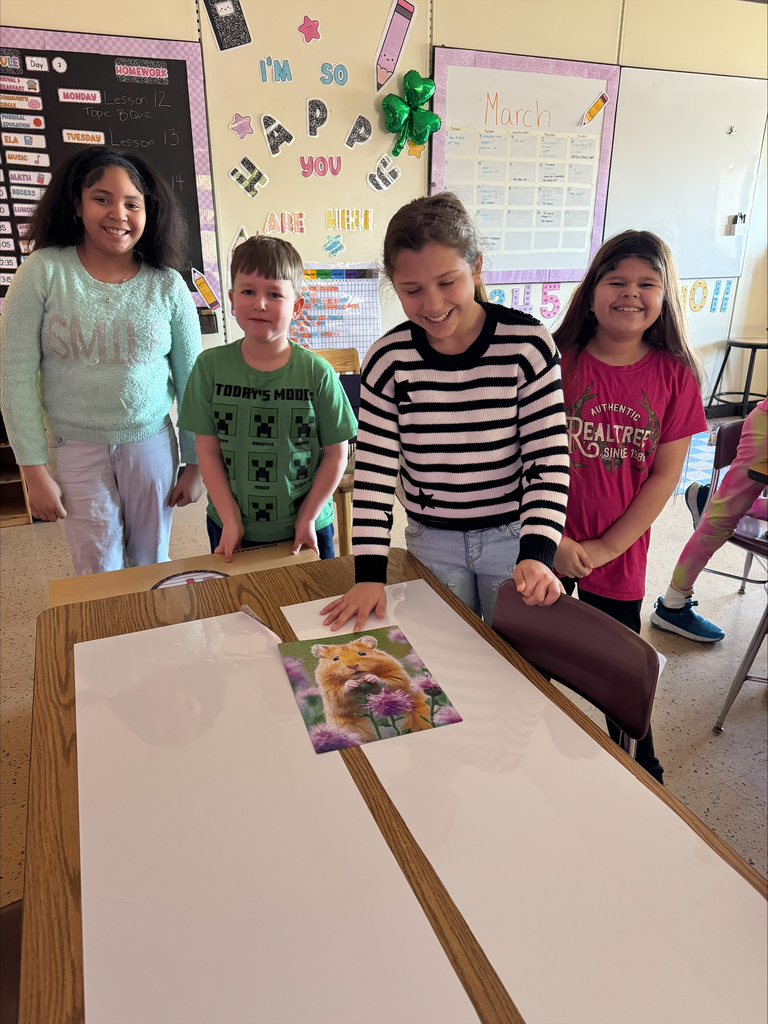 4 students smiling and showing off their completed puzzle