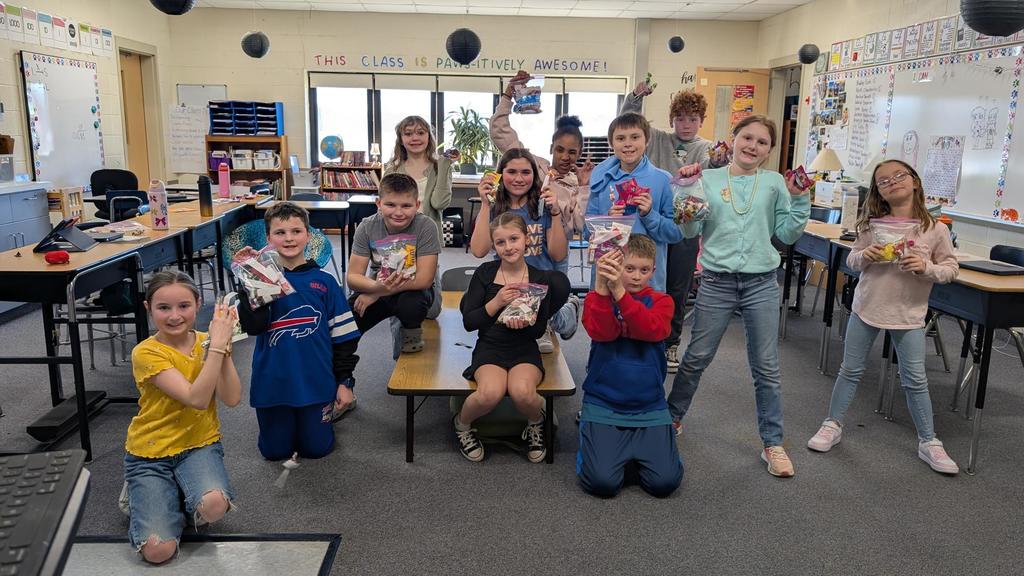 Group of students smiling while holding candy bags