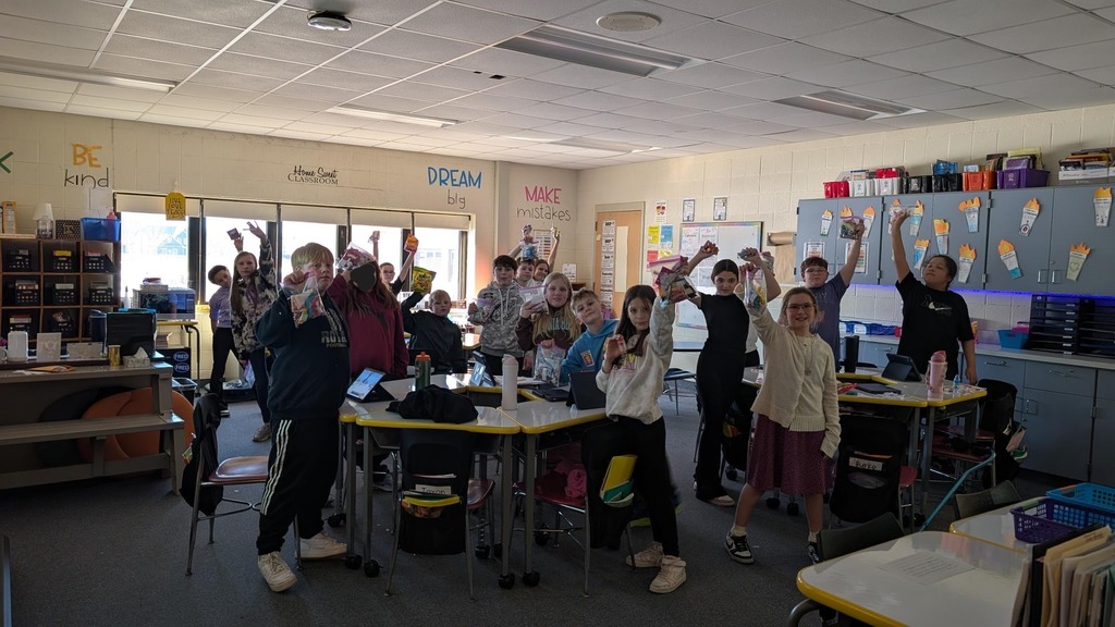 Students standing in classroom smiling