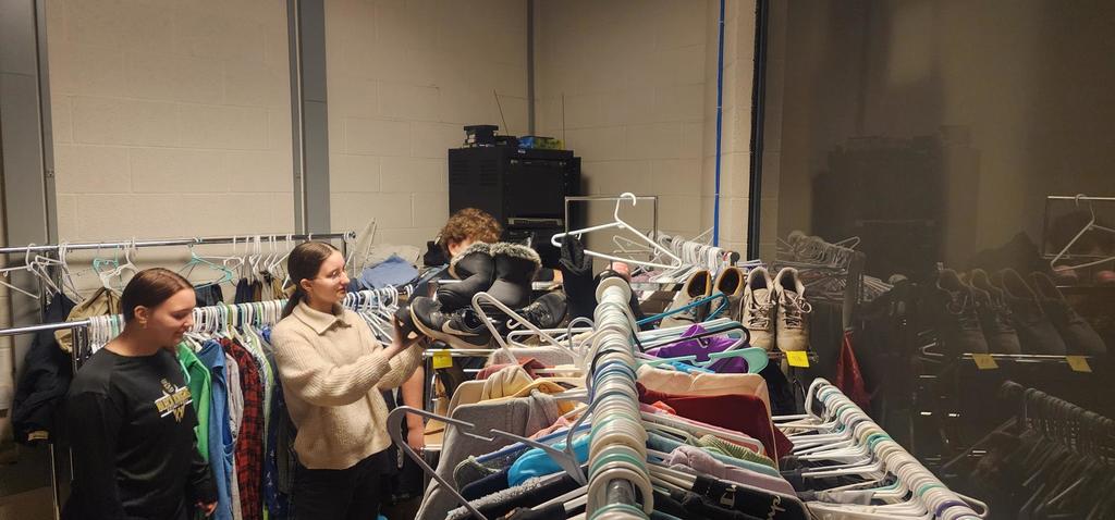 High school students sorting through clothing racks