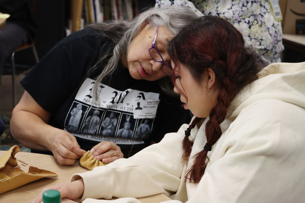 the instructor shows a student a stitch.