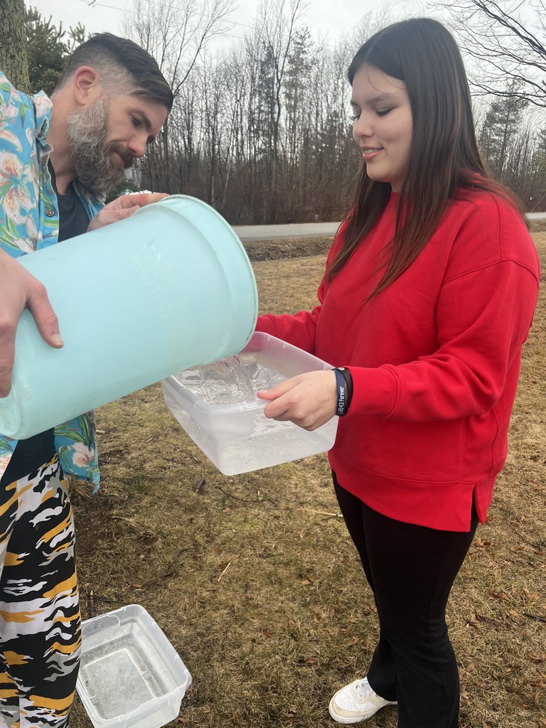 Mr. Reynolds and a female student collecting tree sap with a bucket