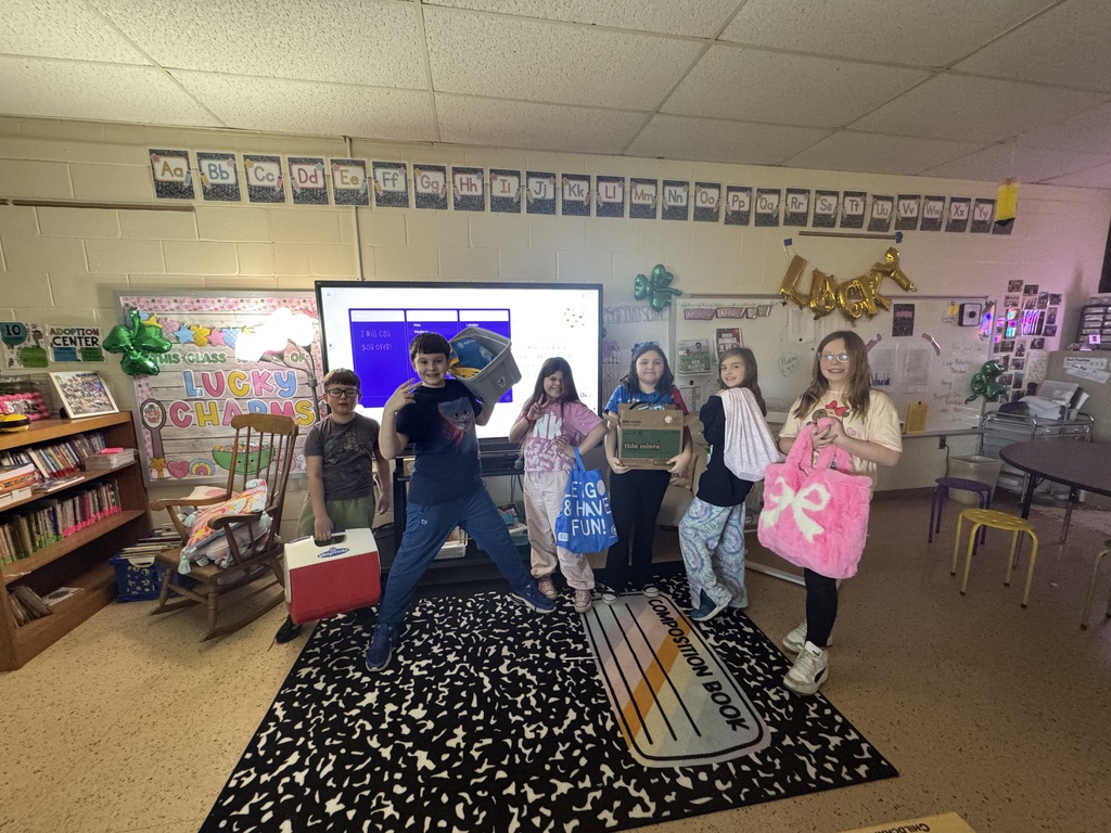 students hold a box, a cooler, a pillowcase and bags.