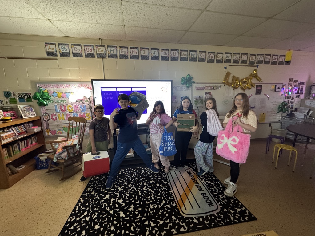 students hold a box, a cooler, a pillowcase and bags.