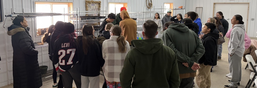 students listen as farm workers explain maple process