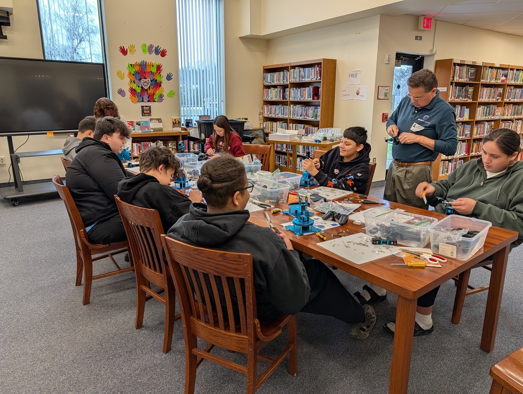 Students at table building robotic arms