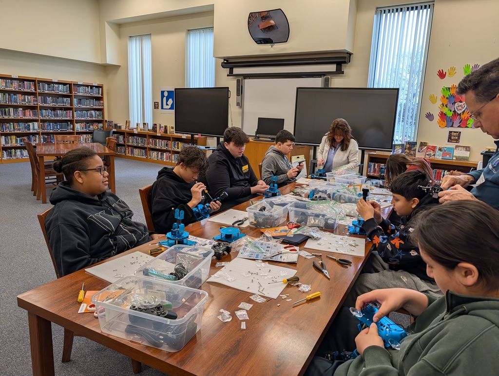 Students at table building robotic arms