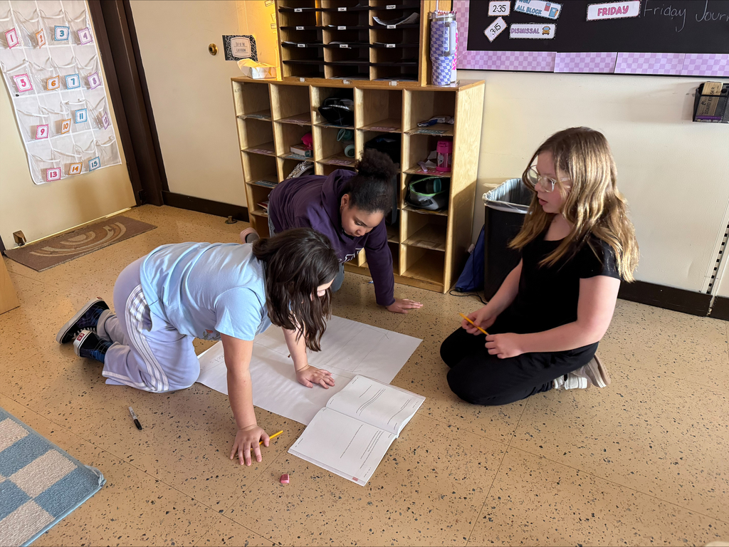 Students create a word problem on a big piece of paper