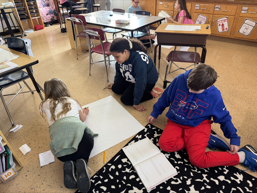 Students create a word problem on a big piece of paper