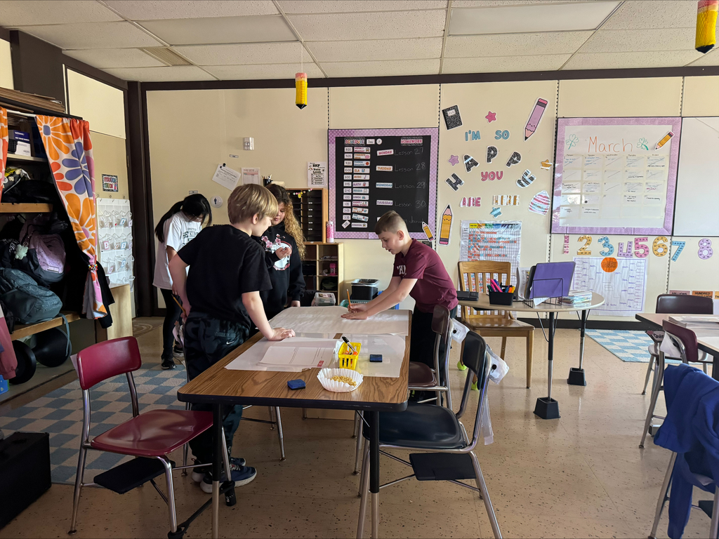 Students create a word problem on a big piece of paper