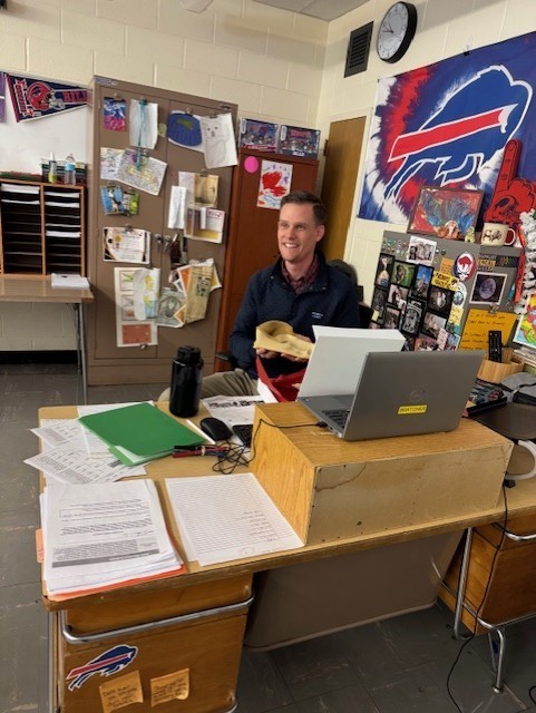 Mr. Bratcher at his desk smiling